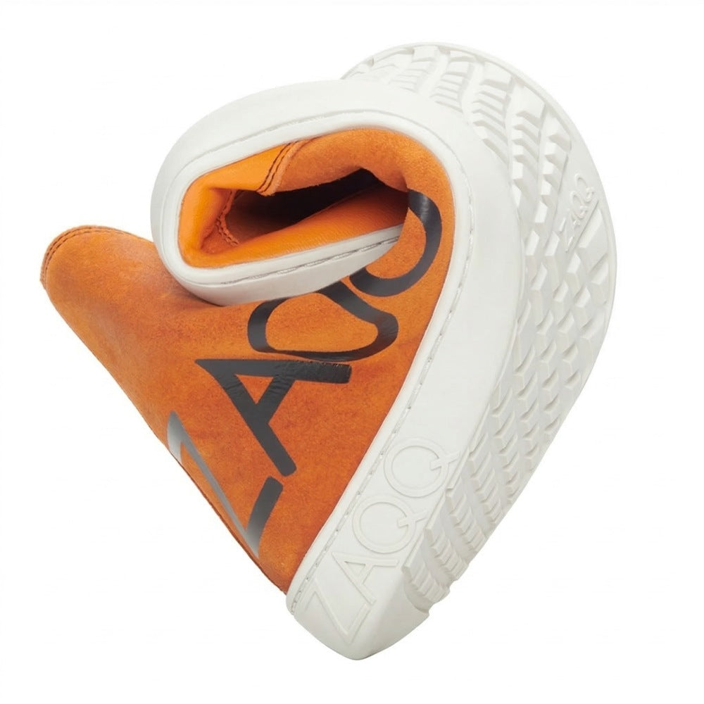 Ein Damen-Sneaker mit orangefarbenem Obermaterial und dicker weißer Sohle ist kunstvoll in Herzform gebogen. Der Name ZAQQ ist auf dem Schuh zu sehen und bietet eine spielerische Abwandlung des traditionellen Designs. Dies ist das Modell SQYLA Orange.