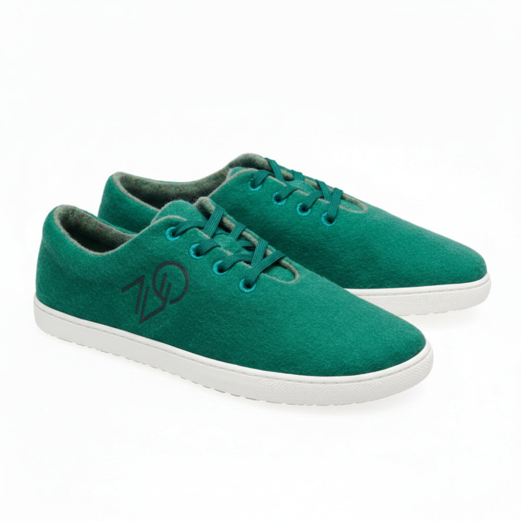 Ein Paar grüne LIQE-Sneaker von ZAQQ, im schlichten Schnürstil gestaltet, mit dezentem Logo an der Seite und ergänzt durch weiße Sohlen.