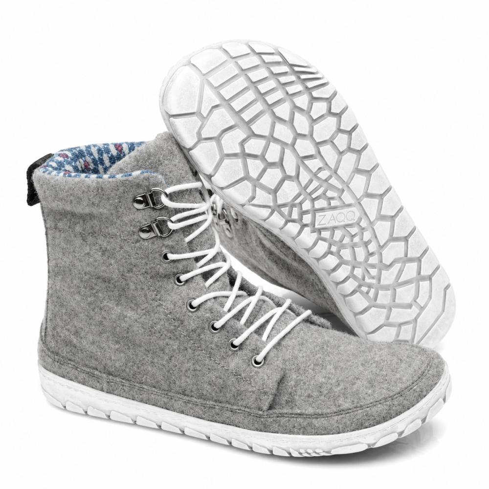 Exposé est une paire de sneakers QICE Grey à tige haute de ZAQQ avec des lacets blancs. Une chaussure est debout tandis que l'autre est inclinée pour mettre en valeur la semelle extérieure texturée et à motifs.
