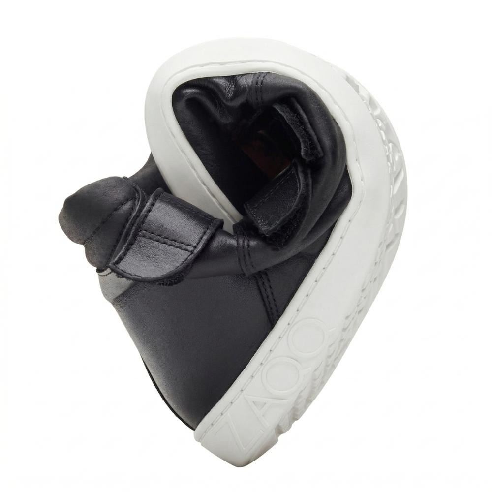 Wir präsentieren den ZAQQ QOOPER Black Barfußschuh, einen flexiblen schwarzen Schuh, der eng auf die Seite gerollt ist, um seine außergewöhnliche Biegsamkeit zu demonstrieren. Er verfügt über eine weiße Sohle mit der Prägung ZOOZ und einen benutzerfreundlichen Klettverschluss, der für ultimativen Komfort und Stil konzipiert ist.