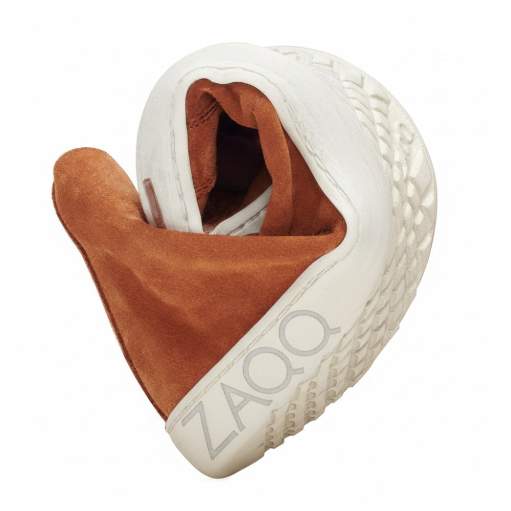 Der QORE Mid Sierra Sneaker von ZAQQ ist elegant in der Mitte gefaltet und präsentiert seine weiße Außenseite mit strukturierter Sohle und die braune Innenseite.