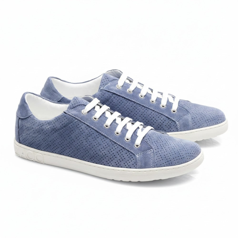 Die SLOQ Blue Sneaker von ZAQQ sind aus hellblauem Veloursleder gefertigt und verfügen über weiße Schnürsenkel sowie ein perforiertes Design. Die Sohlen weisen ein strukturiertes Muster auf, während das Logo der Marke elegant auf der Ferse eingeprägt ist und sich von einem makellos weißen Hintergrund abhebt.