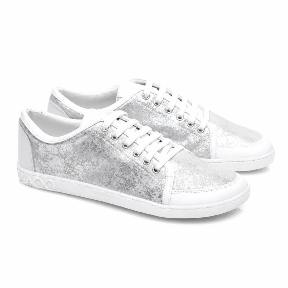 Nous vous présentons le TIQQ Silver White de ZAQQ : Une paire de baskets stylées en cuir nappa de haute qualité avec une texture métallisée argentée saisissante et des semelles blanches. Ces baskets sont dotées de lacets blancs éclatants, de coutures décoratives et d'un détail marquant 4000 sur le côté de la semelle.