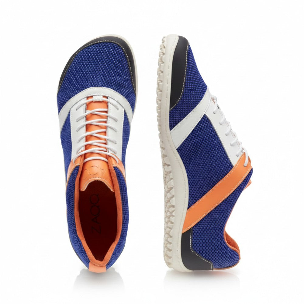 Wir präsentieren den ZARQA Blue von ZAQQ: ein lebhaftes Paar Laufschuhe aus blauem Netzgewebe, weißen Schnürsenkeln und auffälligen orangefarbenen Akzenten. Diese Schuhe zeichnen sich durch ein einzigartiges Streifendesign an der Seite und eine strukturierte Sohle aus, die sowohl die Atmungsaktivität als auch die Haltbarkeit verbessert. Von oben und von der Seite betrachtet bietet der ZARQA Blue eine tadellose Mischung aus Leistung und Stil.